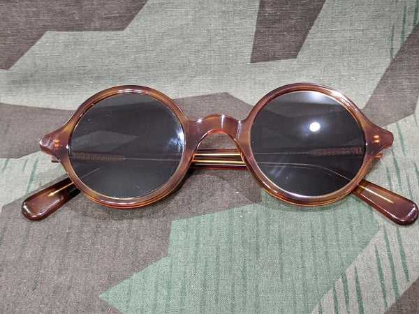 Reproduxtion WWII German round rimmed sunglasses with a faux tortoise shell pattern and tinted lenses. Vintage 1940s style.